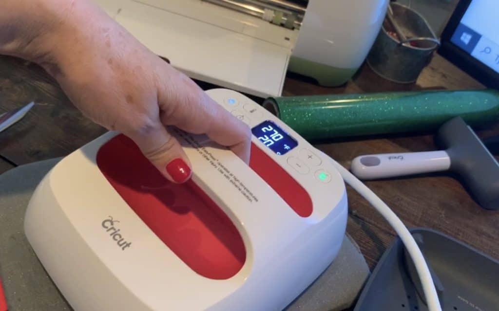 using Easy Press 2 to adhere the heat transfer vinyl to the leather earring