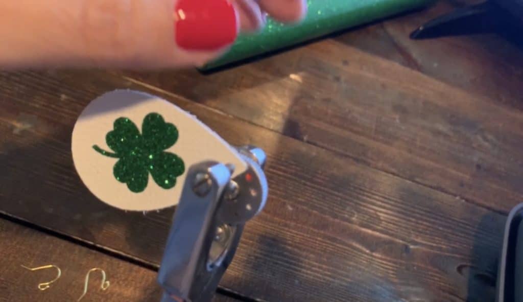 using a leather punch to punch hole in the St Patrick's Day leather earrings