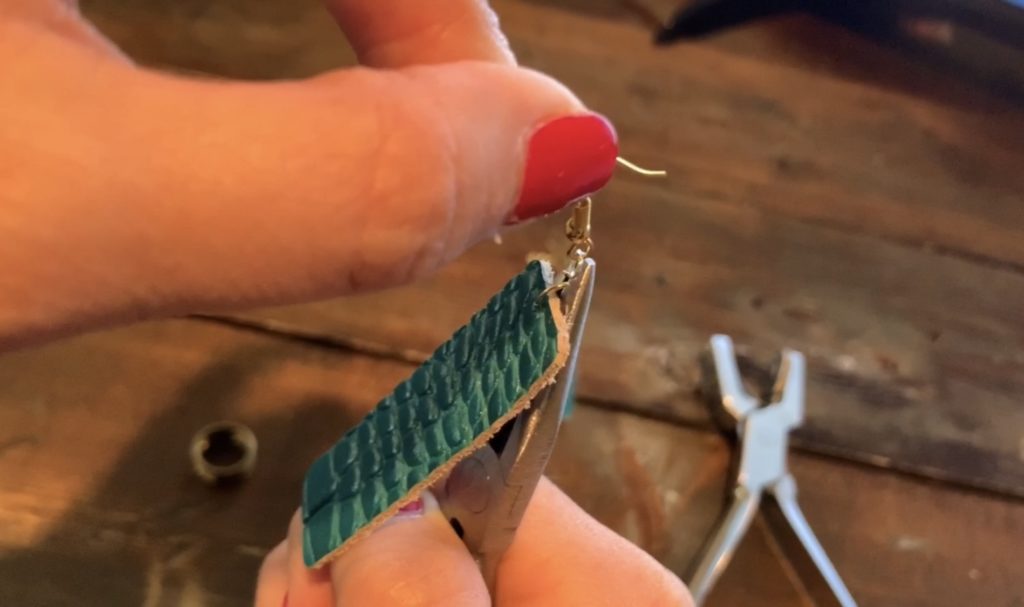 putting hook onto the leather earrings