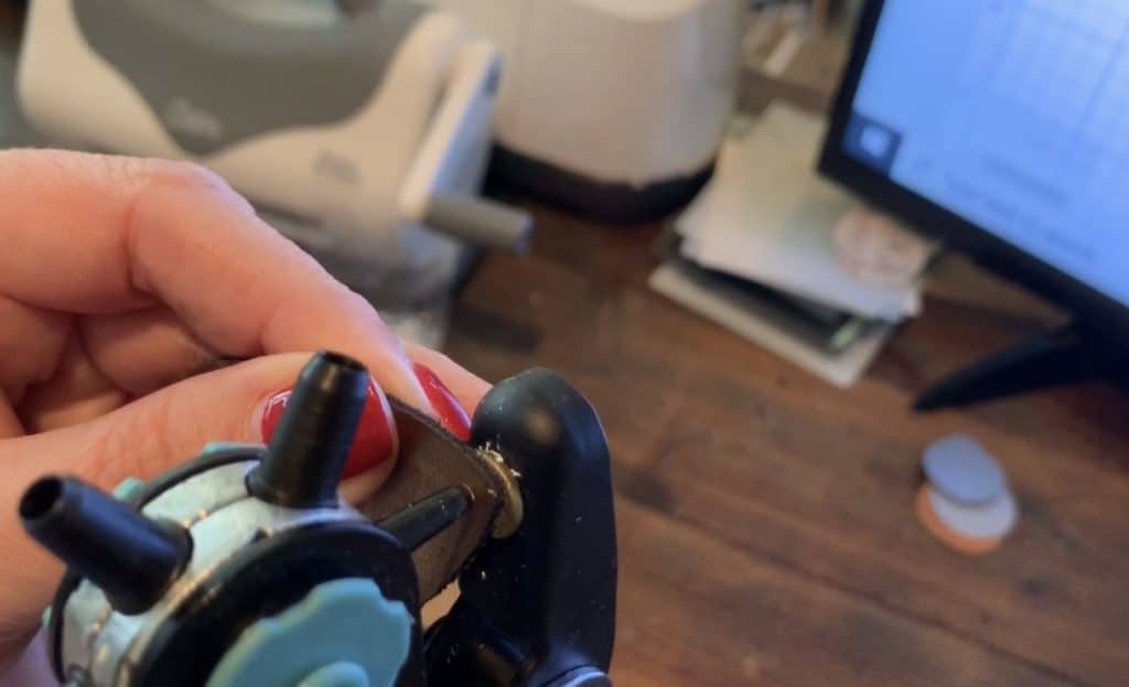 punching a hole in the leather earring with a leather punch