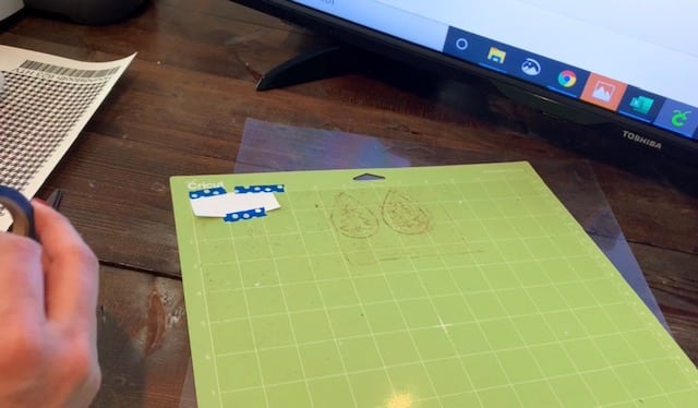 heat transfer vinyl taped onto standard green Cricut mat with Washi tape