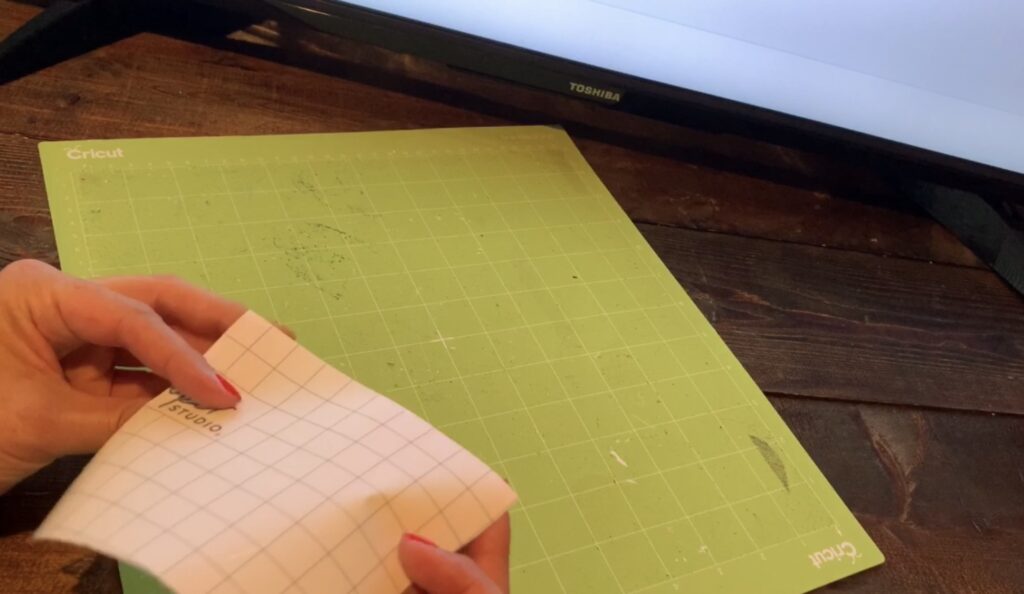 Placing transfer tape onto a Cricut mat for cutting diy earrings