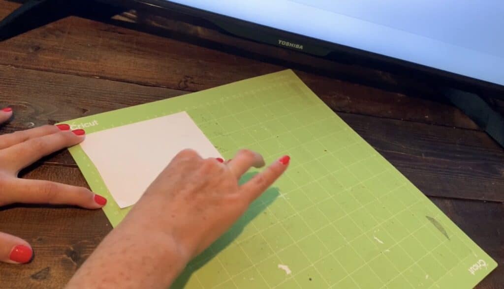 Placing transfer tape onto a Cricut mat for cutting diy earrings
