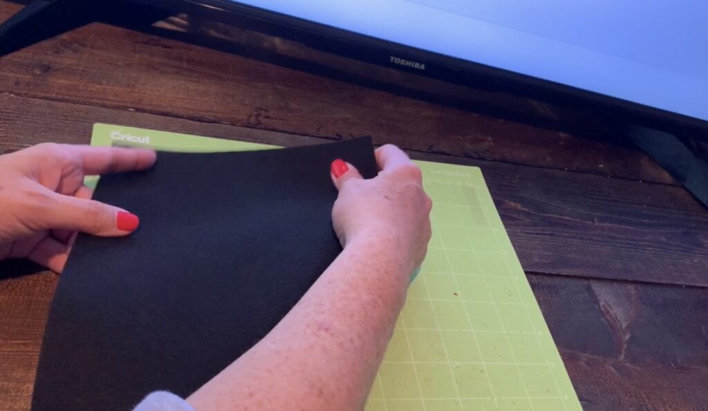 Placing black faux leather onto the Cricut mat