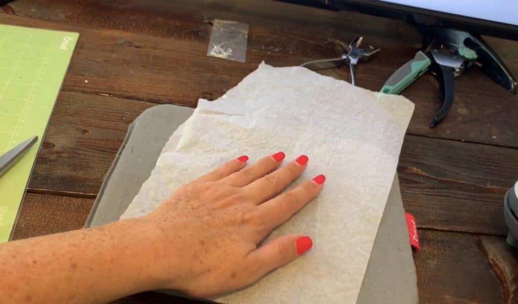 parchment paper on top of the fine glitter hobby lobby faux leather before Cricut easy press