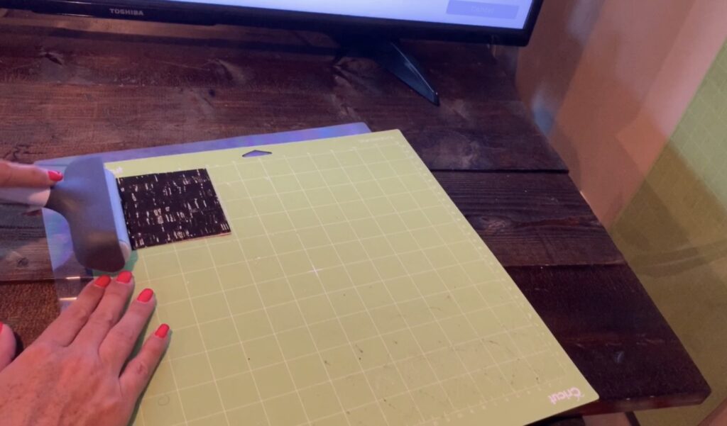 using cricut brayer to press cork onto the cricut mat