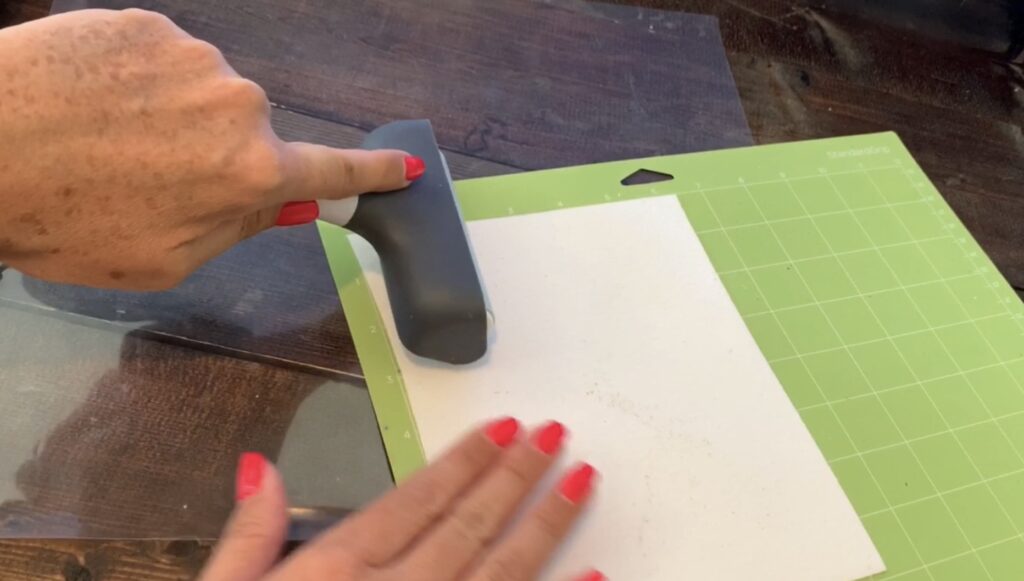 Using brayer to press faux leather onto the Cricut mat