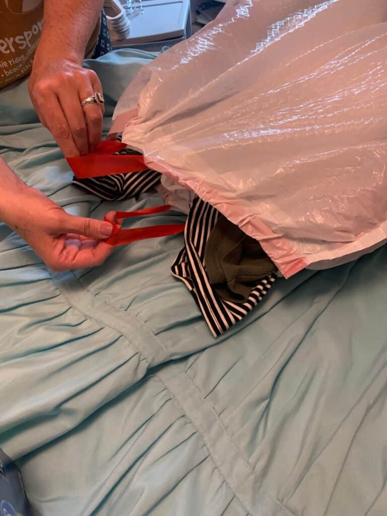 covering hung clothes with a trash bag for college move in day