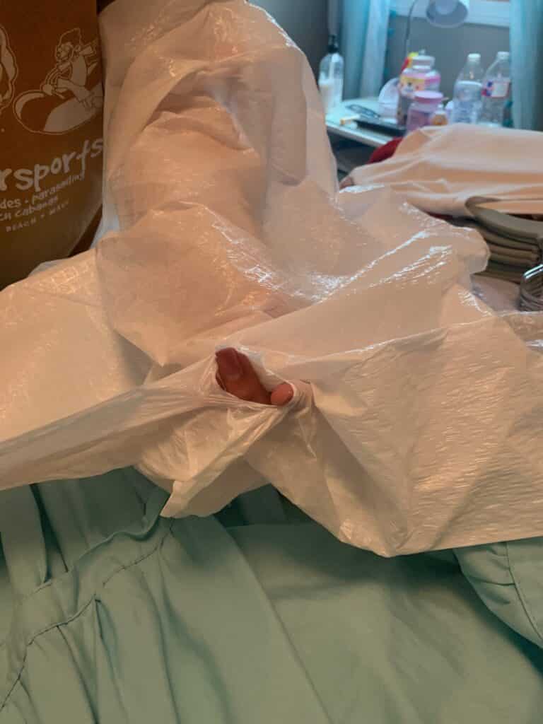 covering hung clothes with a trash bag for college move in day