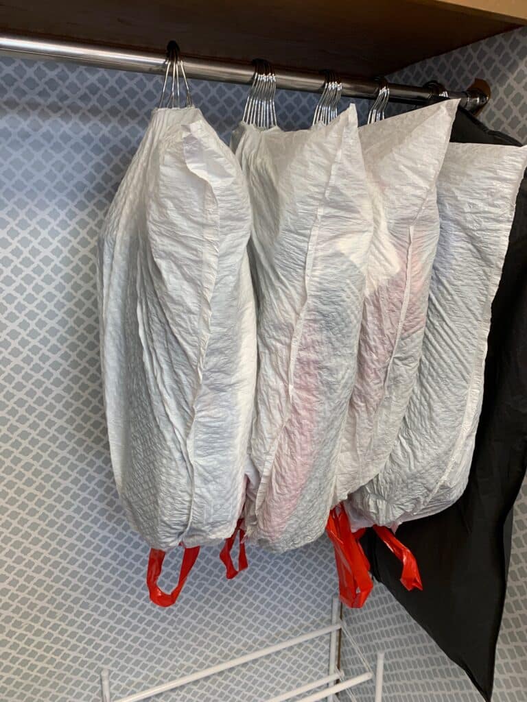 covering hung clothes with a trash bag for college move in day