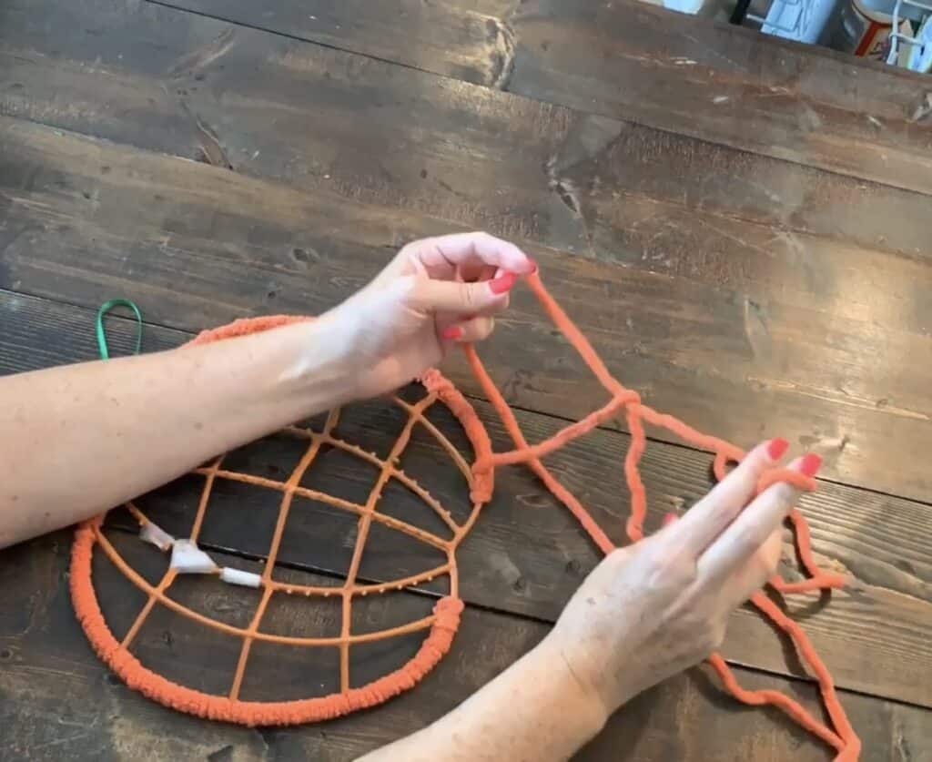 wrapping yarn around the dollar tree pumpkin wreath frame