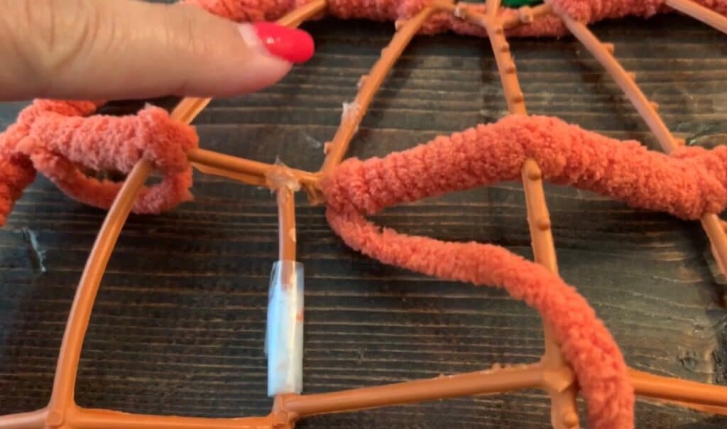 wrapping yarn around the dollar tree pumpkin wreath frame