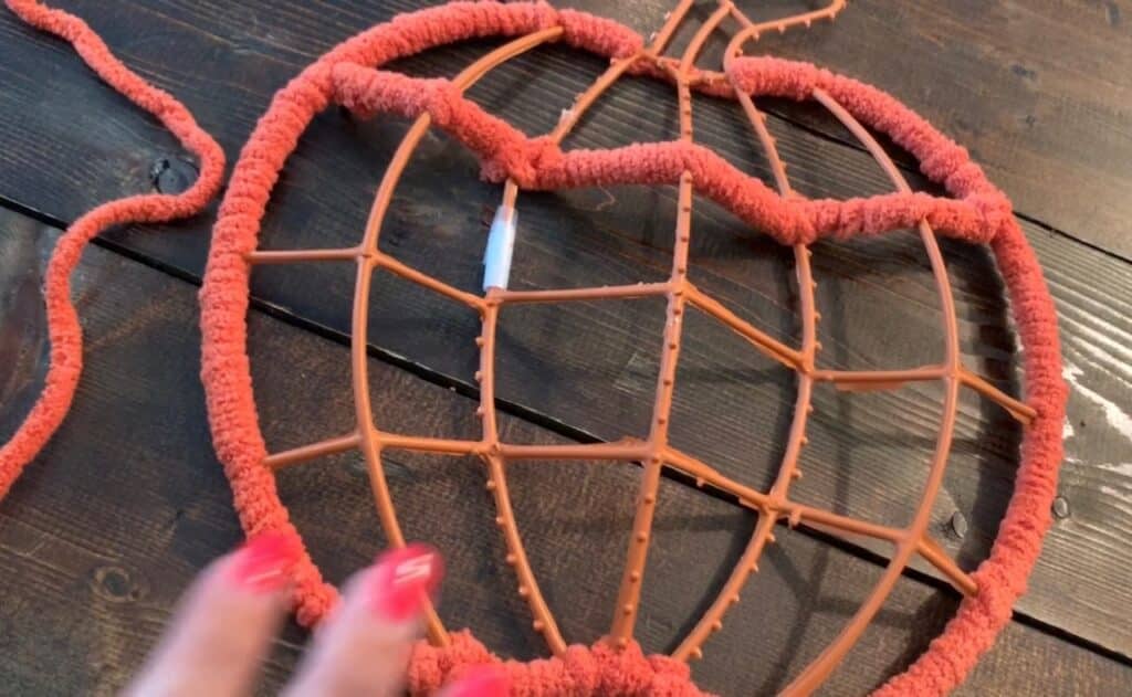 wrapping yarn around the dollar tree pumpkin wreath frame