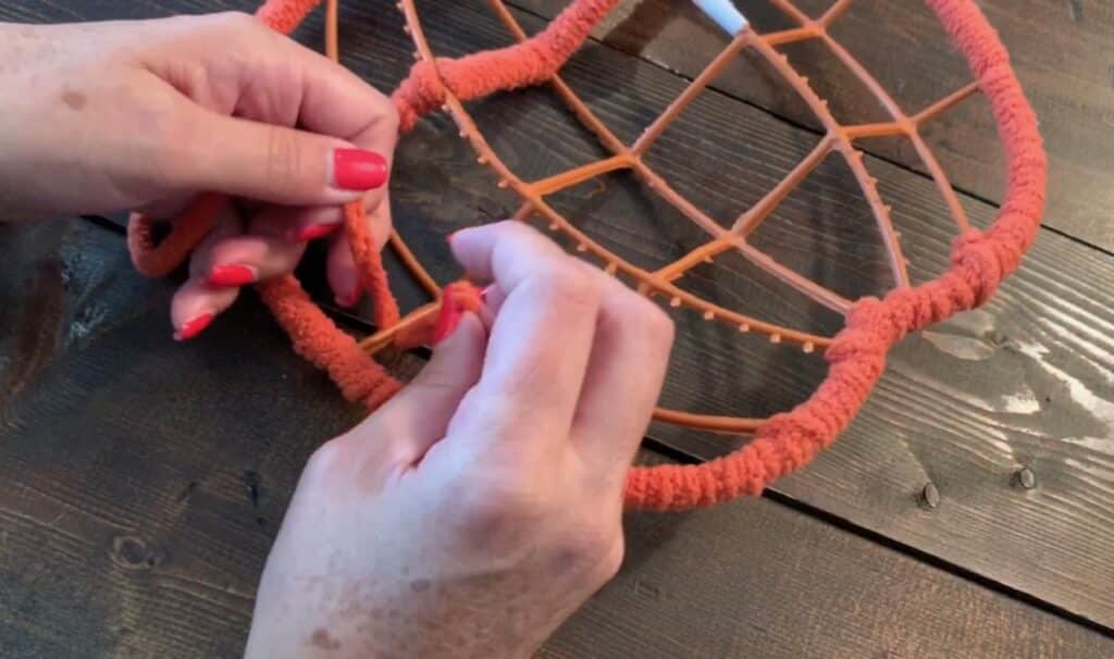 wrapping yarn around the dollar tree pumpkin wreath frame