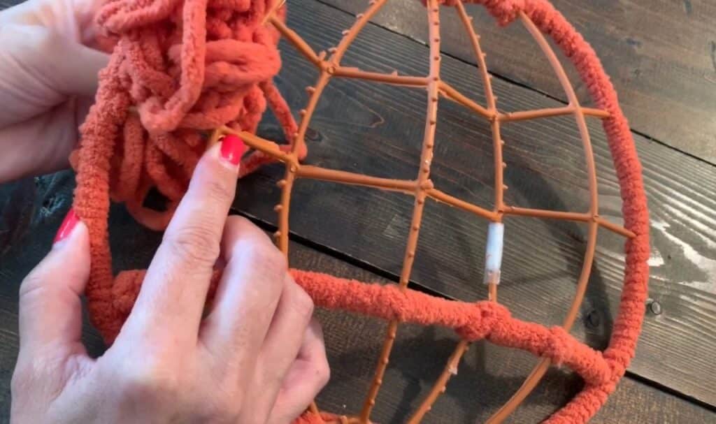 wrapping yarn around the dollar tree pumpkin wreath frame