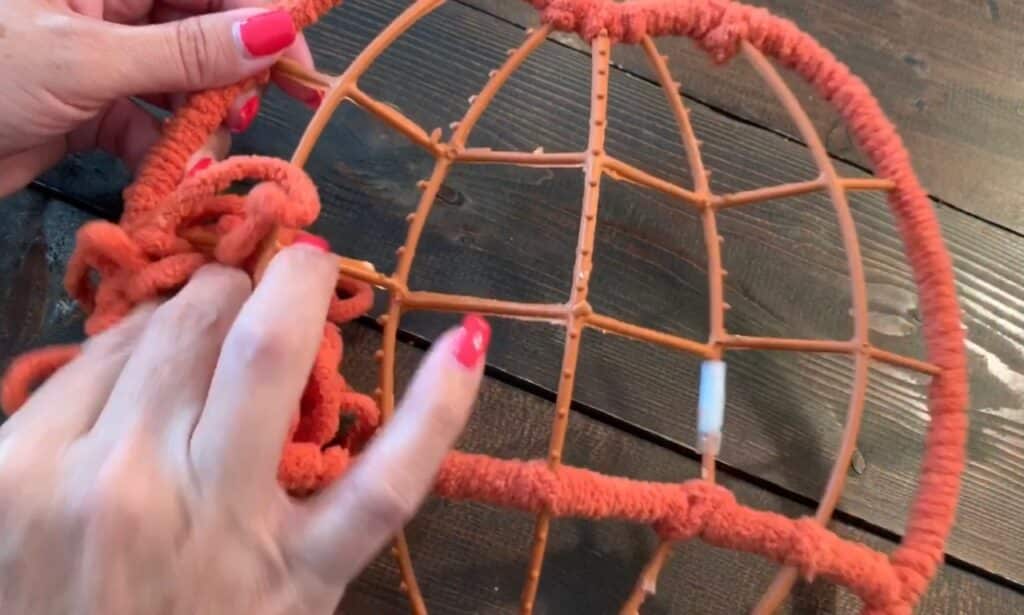 wrapping yarn around the dollar tree pumpkin wreath frame
