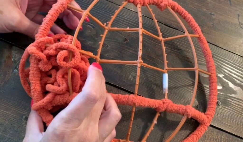 wrapping yarn around the dollar tree pumpkin wreath frame