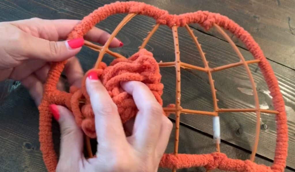 wrapping yarn around the dollar tree pumpkin wreath frame