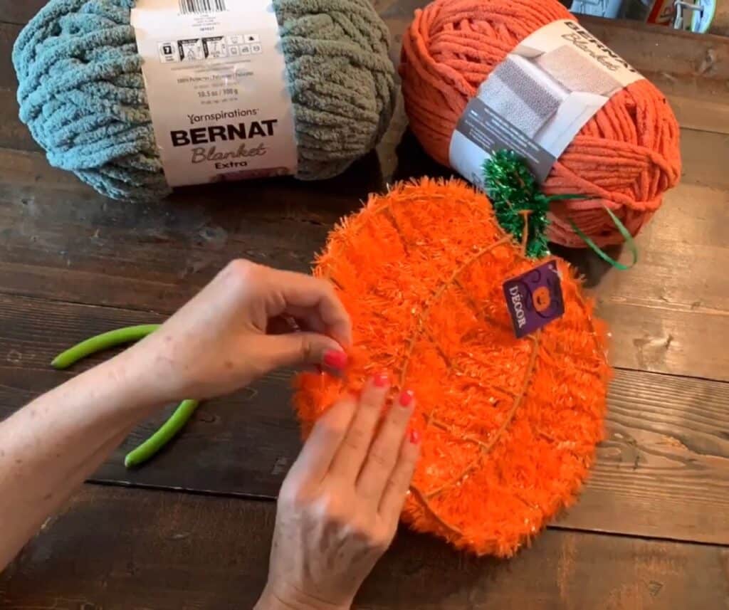 cutting off the tinsel from the Dollar tree wreath with wire cutters