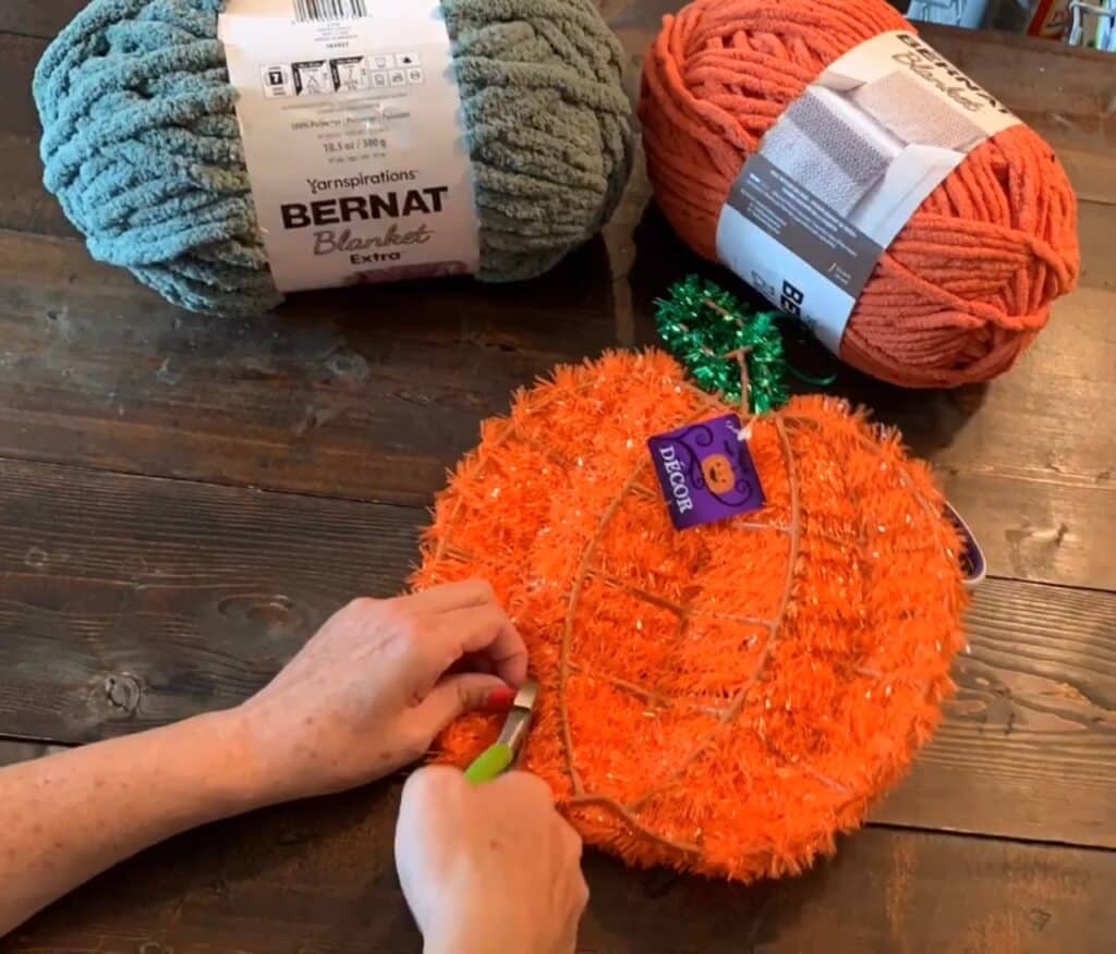 cutting off the tinsel from the Dollar tree wreath with wire cutters