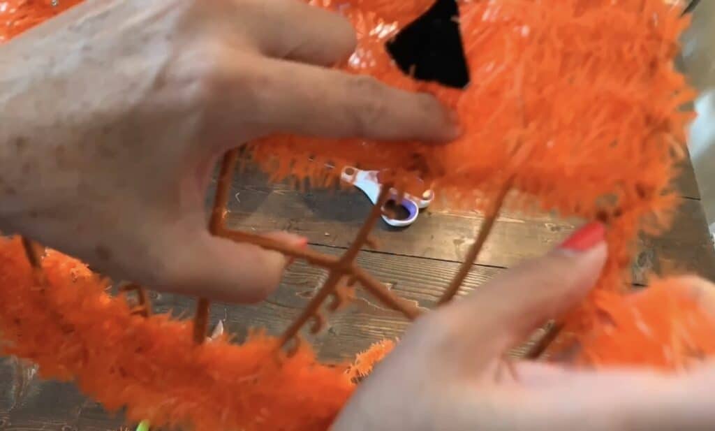 cutting off the tinsel from the Dollar tree wreath with wire cutters