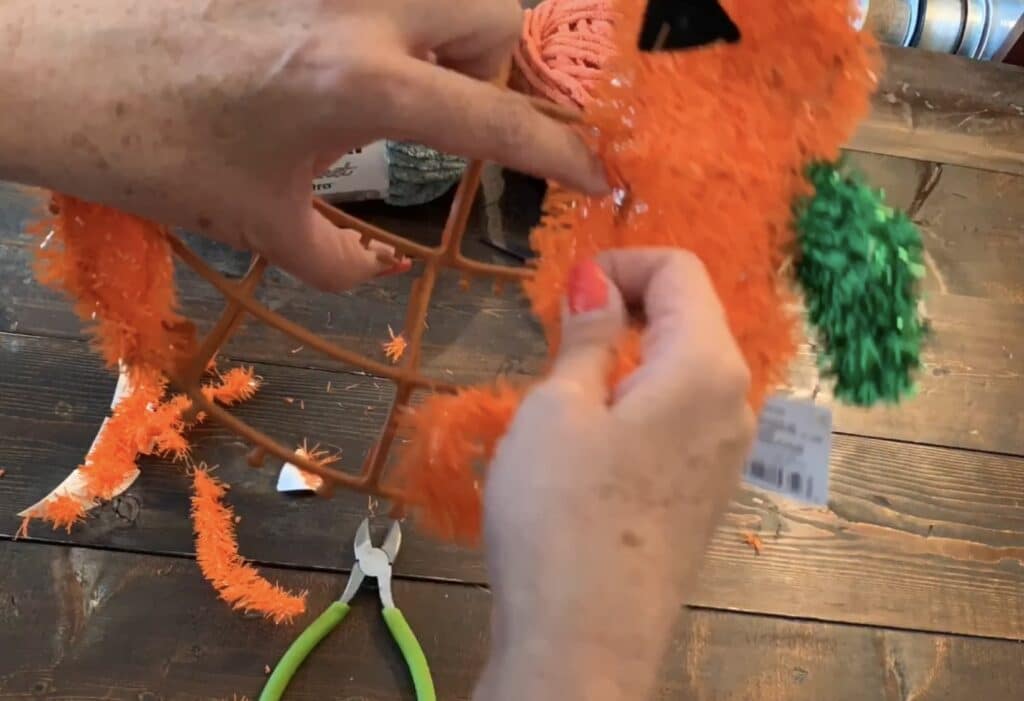 cutting off the tinsel from the Dollar tree wreath with wire cutters