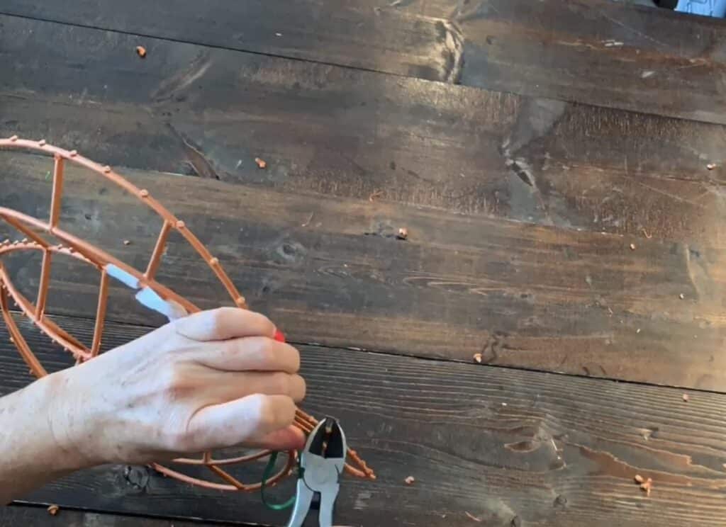cutting pegs off of the dollar tree tinsel wreath
