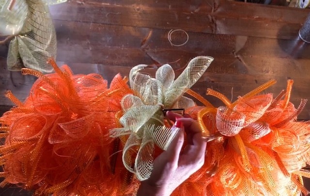 tying on mesh bundles for the pumpkin mesh wreath diy pumpkin stem