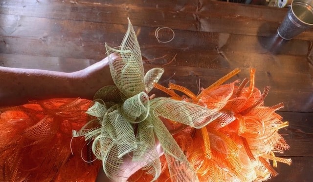 tying on mesh bundles for the pumpkin mesh wreath diy pumpkin stem