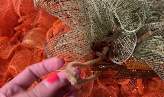 a pipe cleaner tied to back of wreath to hang the pumpkin mesh wreath