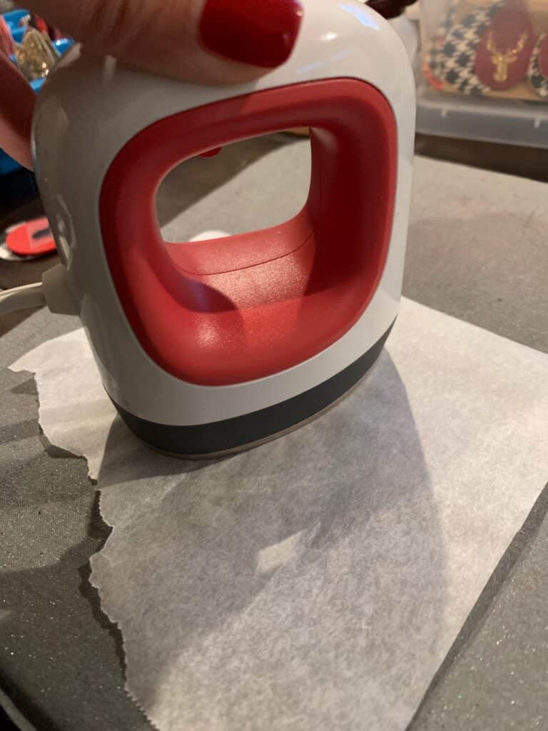 placing parchment paper on top of heat transfer vinyl before applying heat to the faux leather