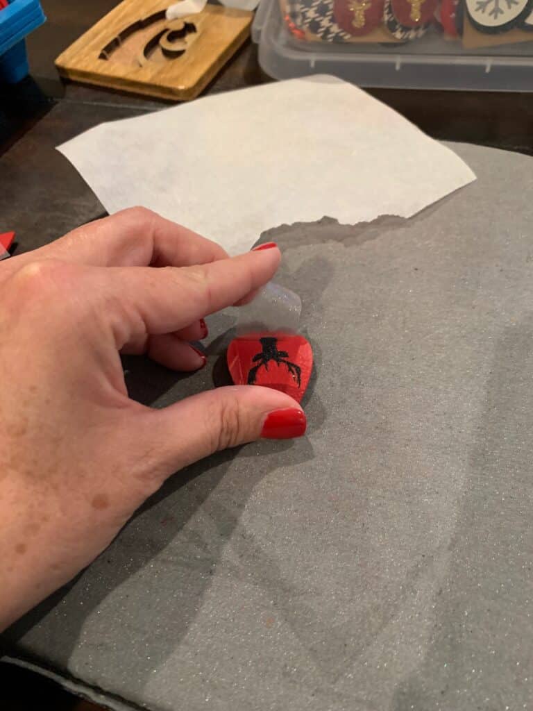 removing heat transfer vinyl carrier paper after ironing the HTV onto leather earrings