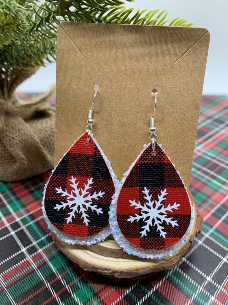 diy snowflake earrings made with red and black buffalo check faux leather and white chunky glitter faux leather