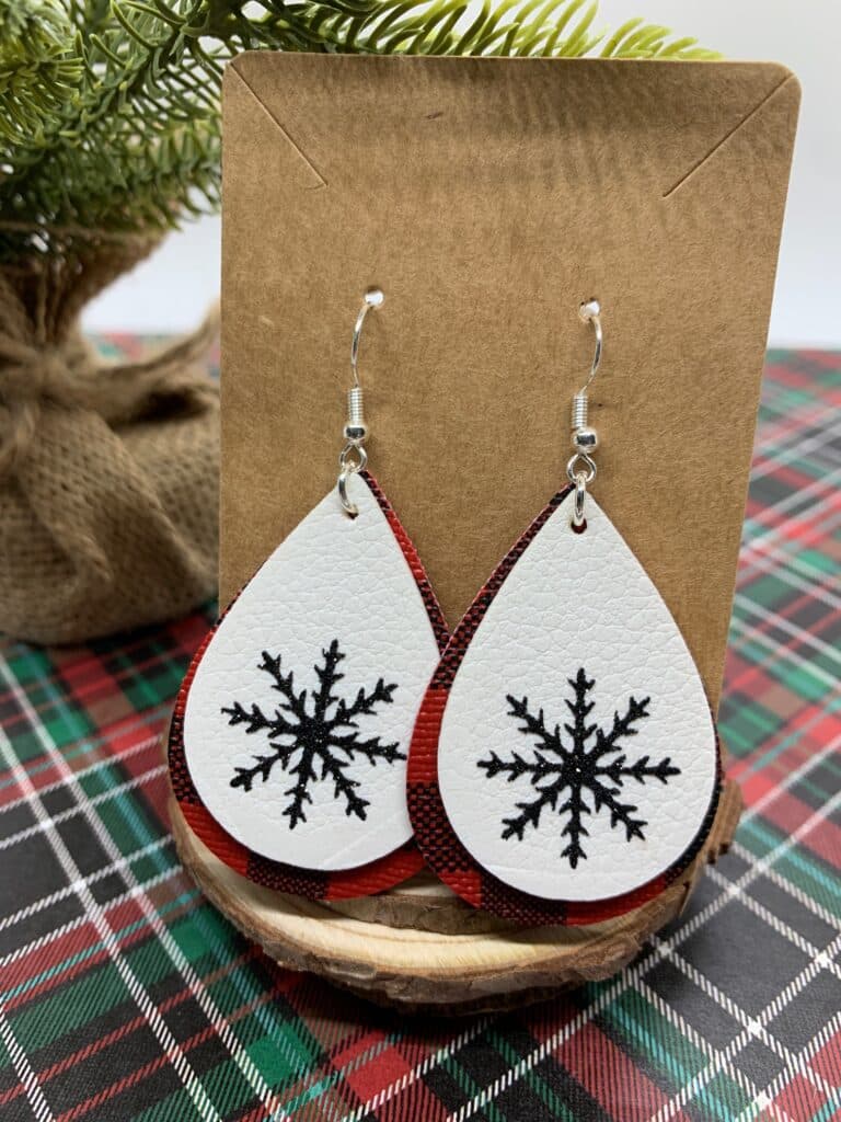 diy snowflake earrings made with red and black buffalo check faux leather and white double sided faux leather