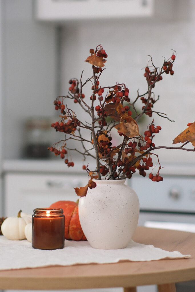 Vase with autumn florals styled on a table to refresh your space for autumn vibes