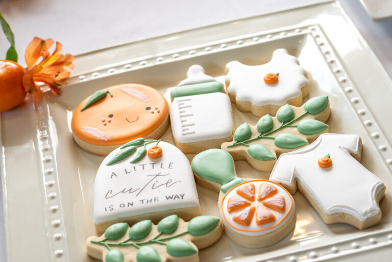 a plat of beautifully decorated baby shower cookies
