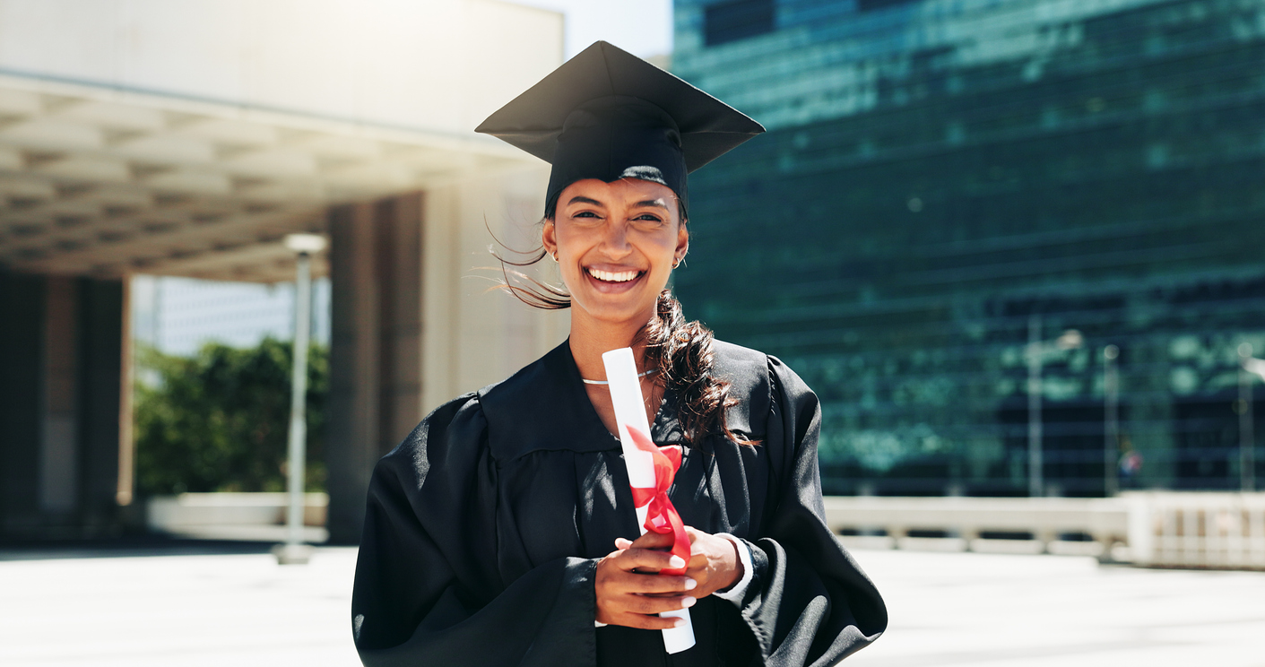 woman holding a diploma in graduation cap and gown
