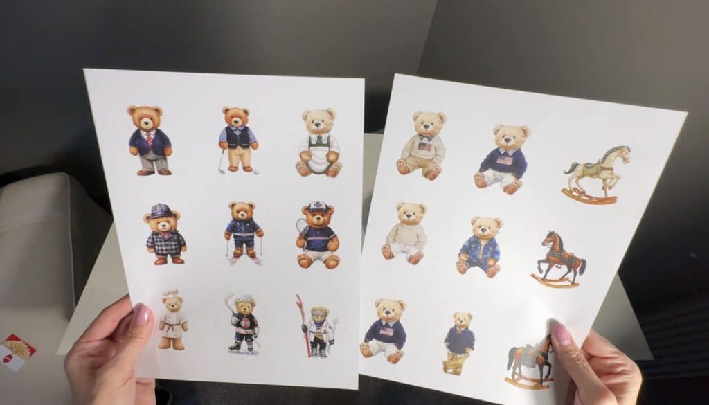 Hands holding printed sheets of teddy bear illustrations for Step 1 of the tape image transfer process.