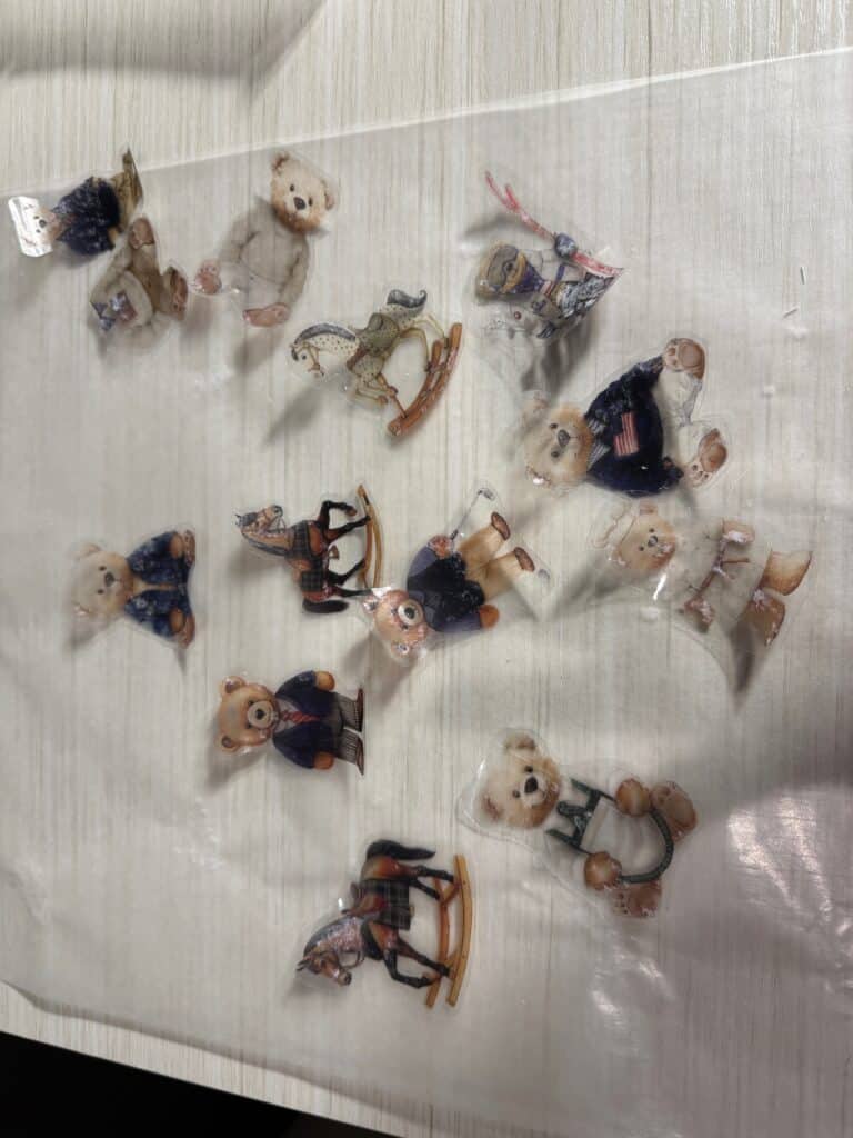 Clear tape transfers with teddy bear and rocking horse designs drying on a plastic sheet after the paper backing has been removed.
