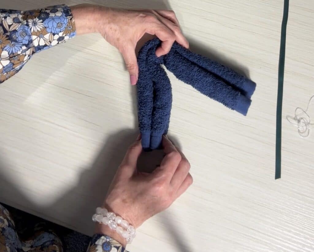 Rolled washcloth folded in half to prepare for shaping the bear.