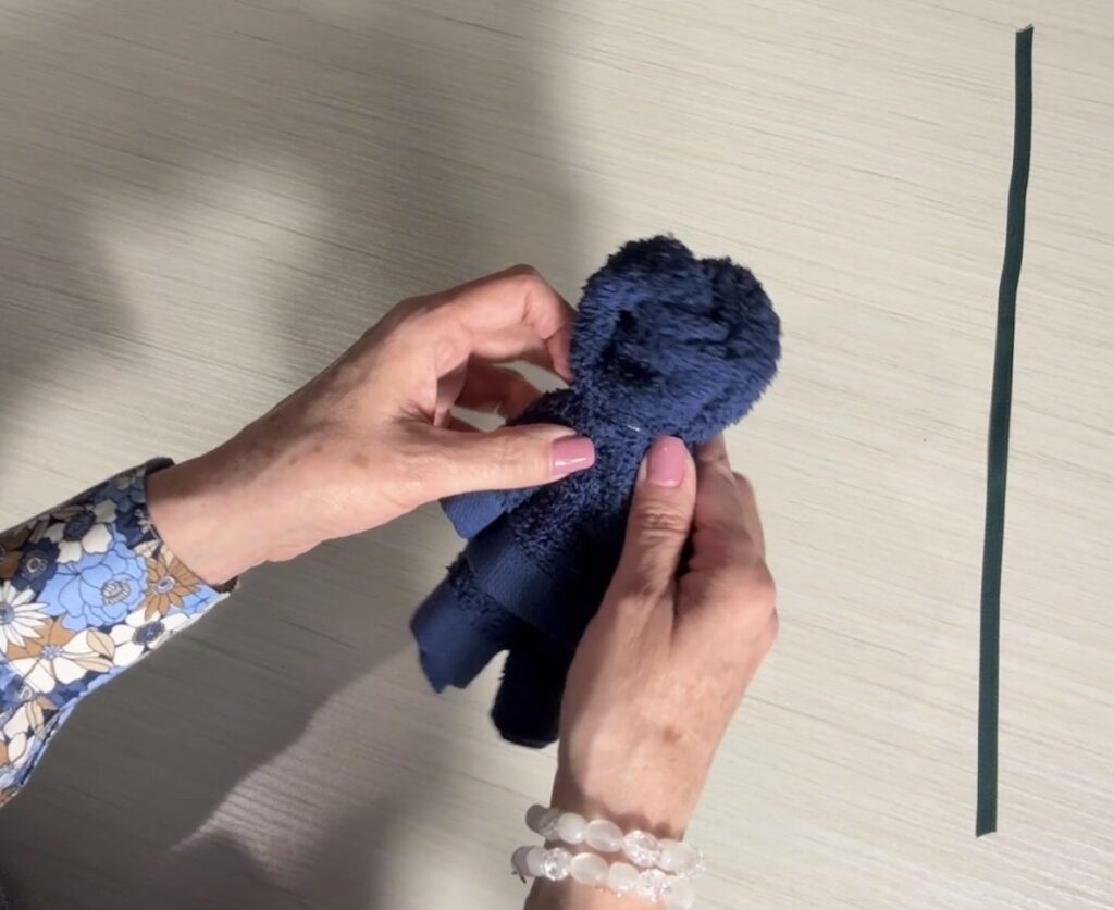 Rubber band wrapped around the top portion of the washcloth to form the bear’s head.