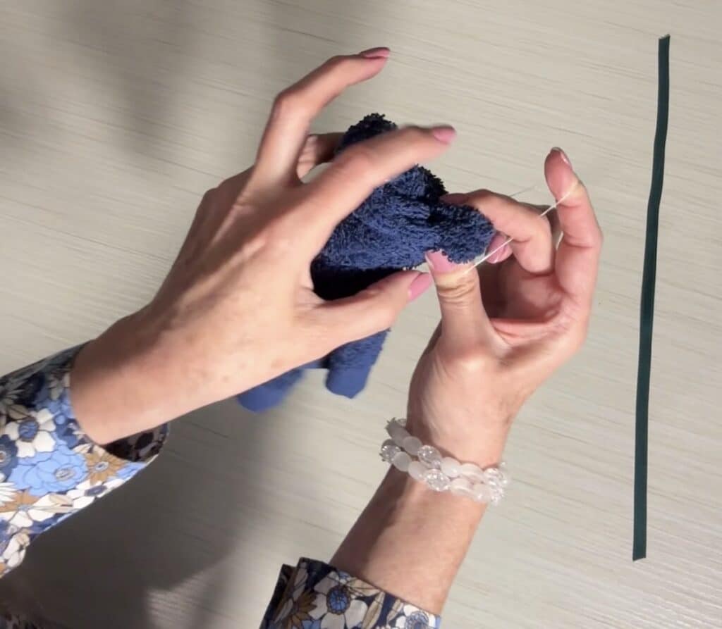 Small sections of the washcloth pinched and secured with rubber bands to form the bear’s ears.